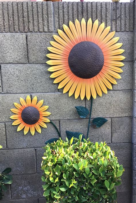 Two Sunflowers On The Side Of A Brick Wall