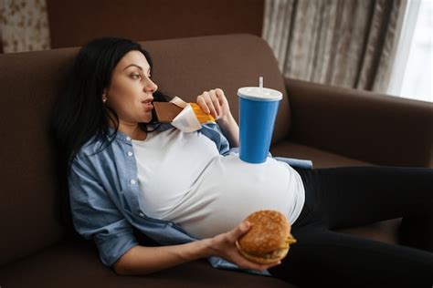 Premium Photo Pregnant Woman With Belly Drinks And Eats Junk Food At