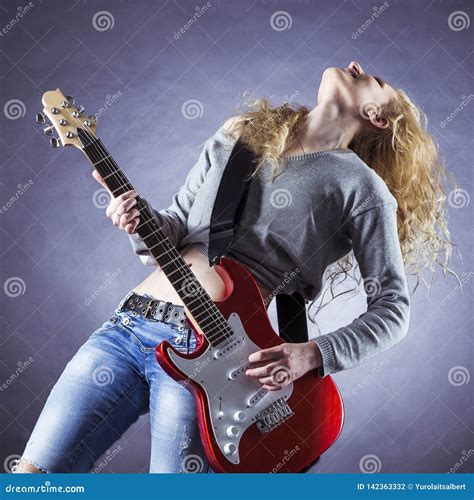 Young And Beautiful Rock Girl Playing The Electric Guitar Stock Photo