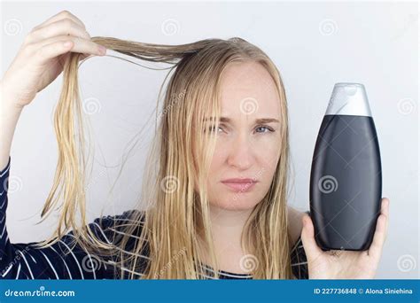 The Girl Looks In The Mirror At Her Oily Hair Then Takes A Shampoo To