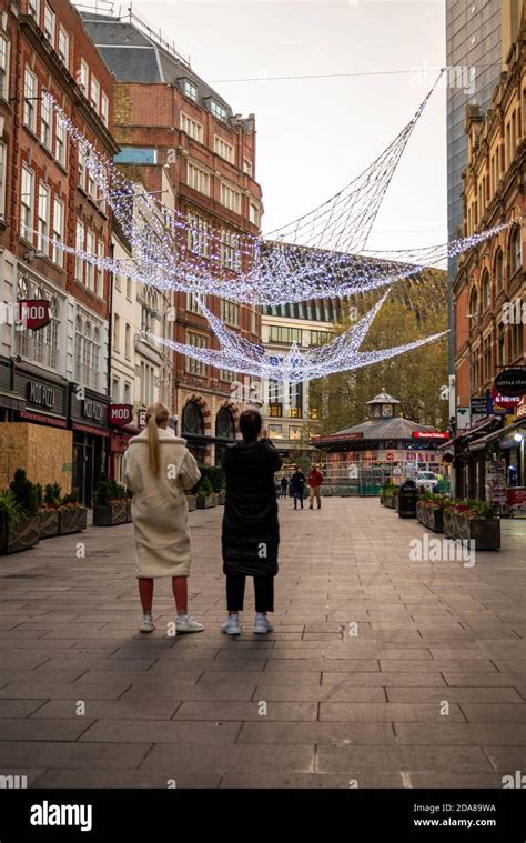 Two Females Looking At The Christmas Lights In Leicester Square Empty