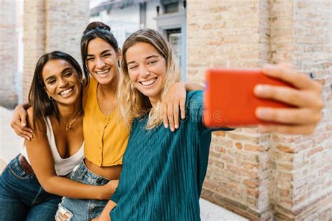 Three Multiracial Young Friends Having Fun Taking Self Portrait With Cell Phone Stock Image