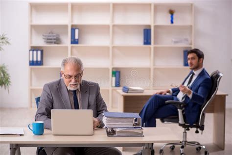 Old Male Boss And Young Male Employee In The Office Stock Photo Image