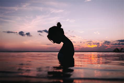 silhouette of a woman in body of water during sunset hd wallpaper wallpaper flare