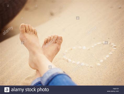Female Feet Closeup Of Woman Standing At The Sandy Beach Next To The