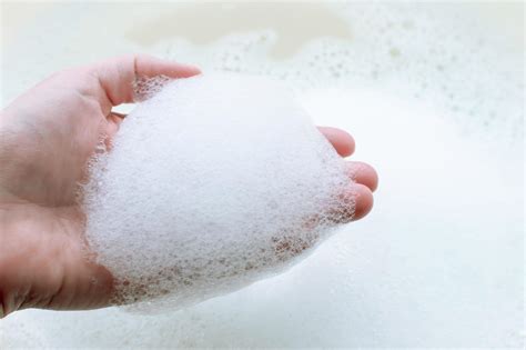 Soap Suds On A Persons Hand On A Background Of Soap Suds The Concept Of Cleanliness And