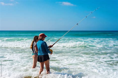 Fishing In The Surf A Grandmother Gives Her Grandbabe Some By Stocksy Contributor