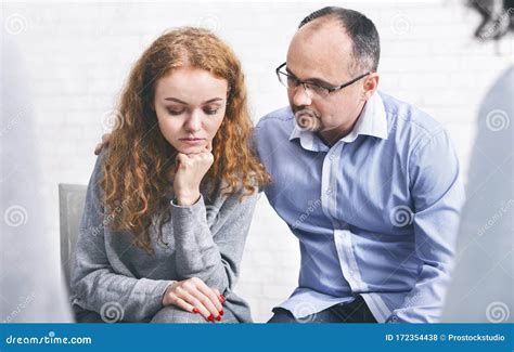 Caring Husband Supporting His Depressed Wife At Marriage Therapy