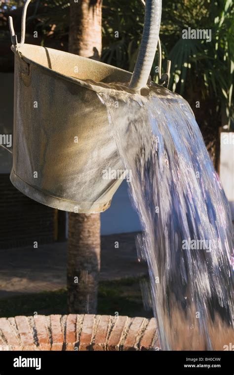 Water Pouring Out Of Bucket Hanging Above Well Stock Photo Alamy