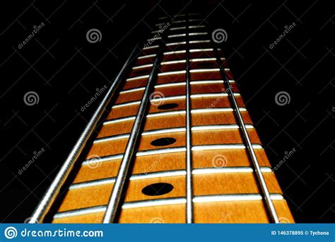 Bass Guitar Neck Four Strings With A Black Background Stock Image
