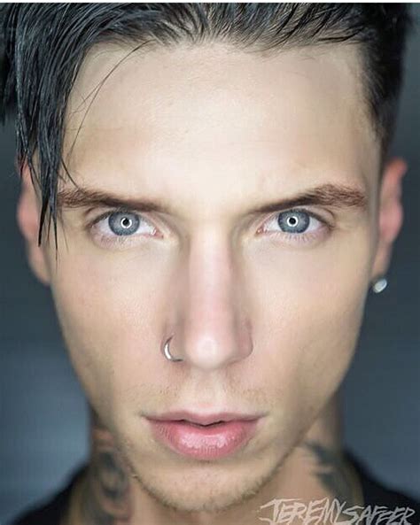 A Man With Piercings On His Nose Looking At The Camera