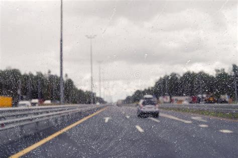 Road View Through Windshield Car Window With Going Rain Drops During