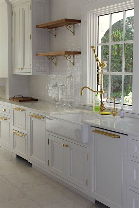 Maybe you would like to learn more about one of these? A white kitchen with brass accents by Nelson Construction ...