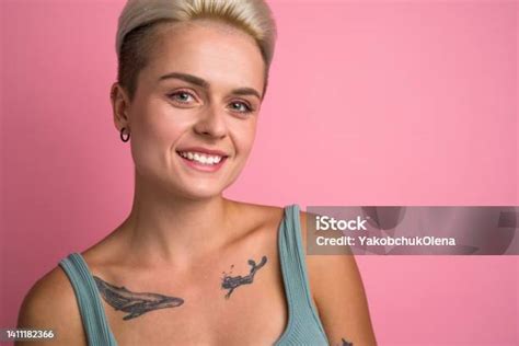 Short Haired Blonde Woman With Tattoos Looking Straight To The Camera