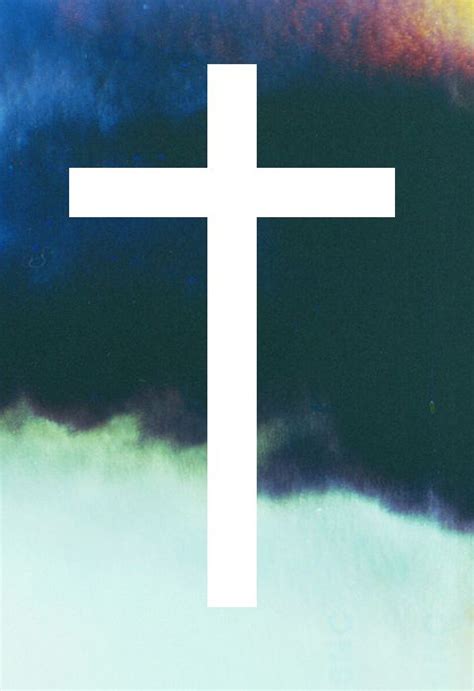 A White Cross On Top Of A Blue And Green Sky With Clouds In The Background