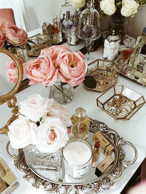 A White Table Topped With Lots Of Pink Flowers Next To Mirrors And