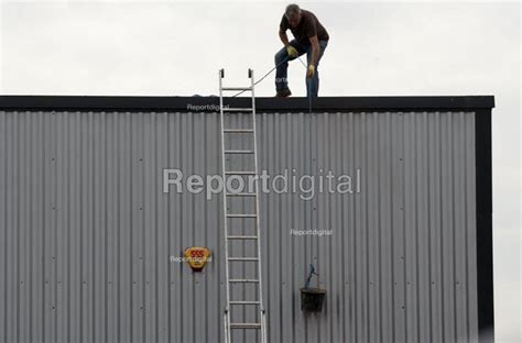 Reportage Photo Of Lowering A Bucket A Worker Clearing A Industrial
