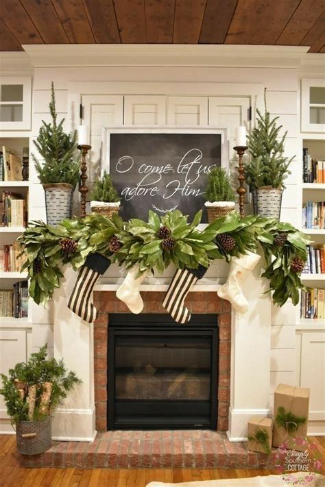 A Fireplace Decorated For Christmas With Greenery And Stockings On The