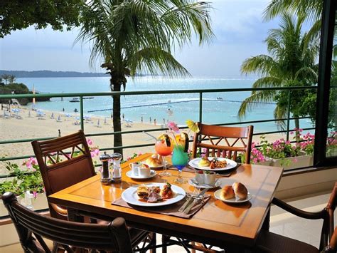 The Table Is Set For Two On The Balcony Overlooking The Beach And Ocean