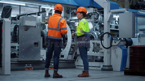 Focused Supervisors Working Modern Machinery Factory Uniformed