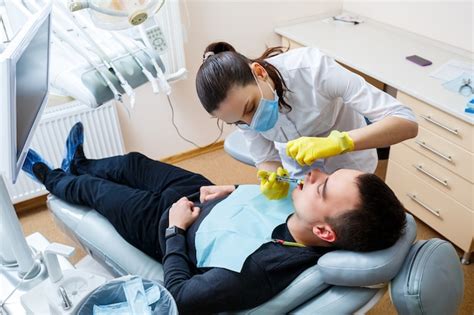 El Dentista Inyecta Al Paciente En La Encía Para Anestesiar Los Dientes