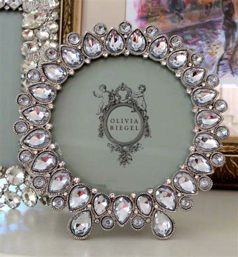 An Ornate Frame With Crystal Stones In Front Of Two Framed Pictures On