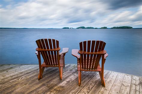 Adirondack Chairs On A Wooden Dock On A Calm Lake In Muskoka Stock