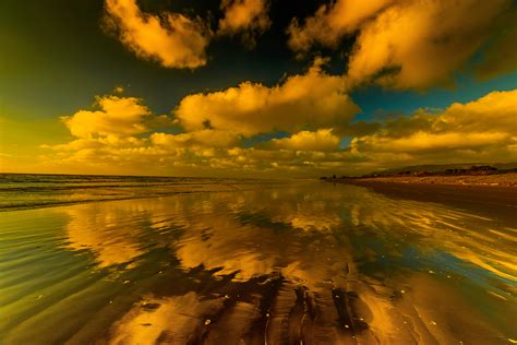 Sunset Clouds Reflected On The Sand