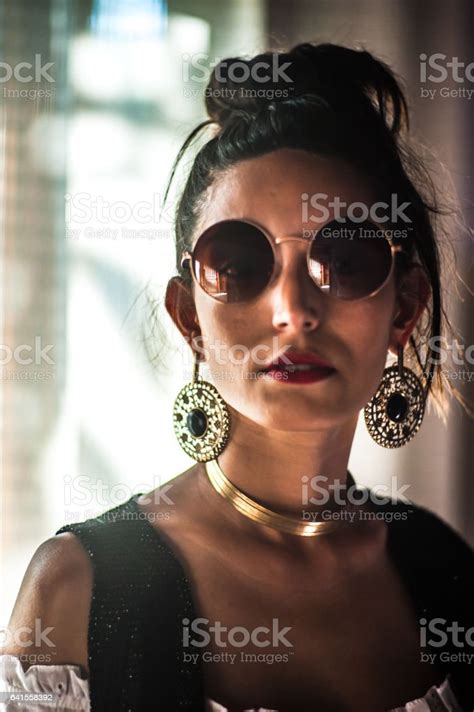 Young Woman Brunette And Lean Wearing Sunglasses Poses Outdoors Stock