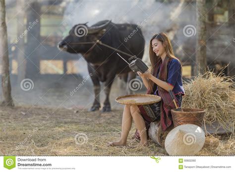 asian woman wearing traditional thai culture in field vintage style listening radio on buffalo