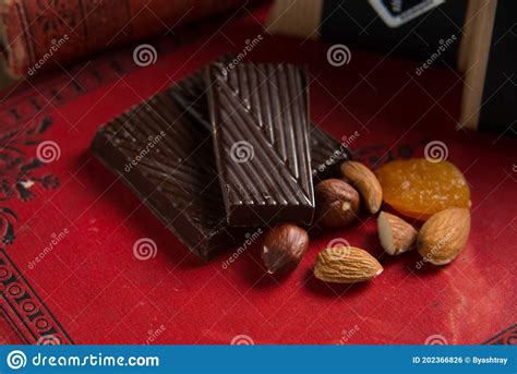 Close Up Of A Homemade Chocolate Bar With Raisins Dried Apricot And Nuts On Red Book Background