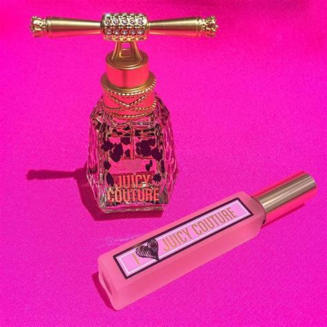 A Bottle Of Juicy Couture Next To A Pink Lipstick Tube On A Pink Background