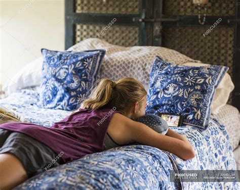 Teenage Girl Lying On Bed And Reading — Teenager Mobile Phone Stock