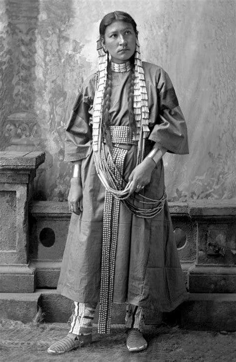 an old black and white photo of a woman in native clothing