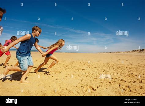 Group Of Kids Run Holding Hands On The Sea Beach Stock Photo Alamy