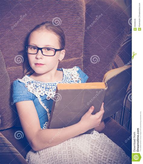 Girl Reading A Book At Home Sitting In An Armchair Stock Image Image