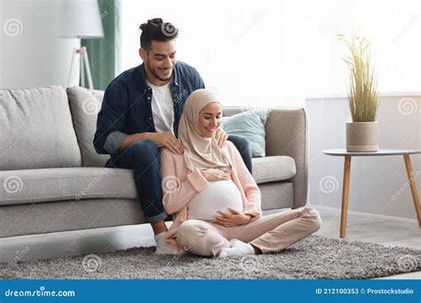 Caring Arab Husband Making Shoulder Massage For Pregnant Muslim Wife At Home Stock Image Image