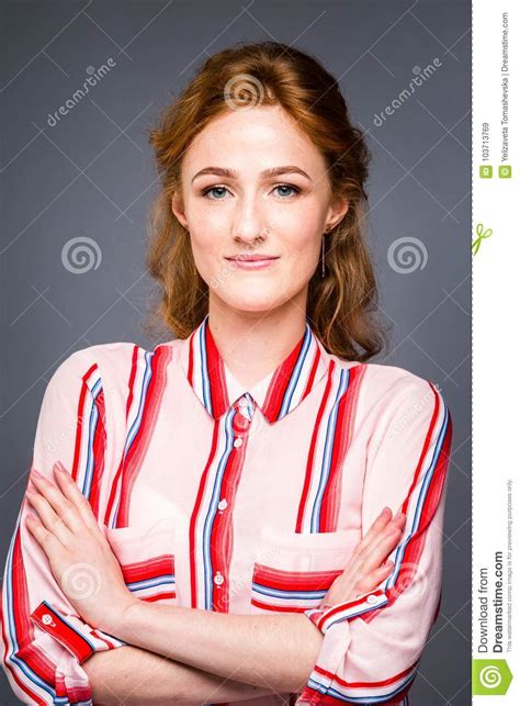 Portrait Of A Young Red Haired Beautiful Girl In The Studio On A Gray