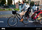 Eine Mutter trägt ihr Kind Fahrrad durch die Straßen von Prenzlauer ...