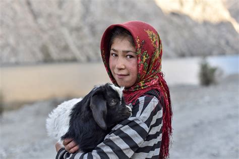 She is 14 years old, and is wearing a yellow dress and has a black hijab (headscarf). Fann Mountains: Trekking to the 7 lakes - Against the Compass