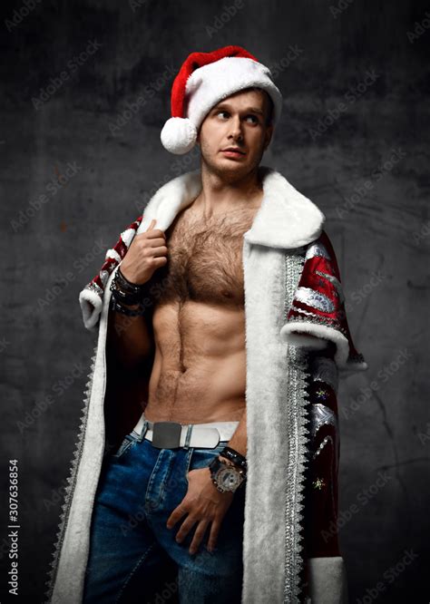 Sexy Man Wear Red Santa Claus Costume For Christmas For Christmas Party With Naked Torso And