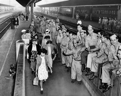 japanese american internees returning from a relocation camp walk past
