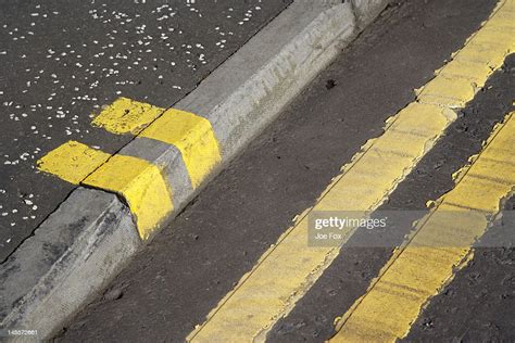 Double Yellow Lines On A Road And Pavement Curb High Res Stock Photo