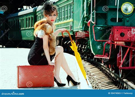 Retro Girl Sitting On Suitcase At The Train Station Royalty Free Stock