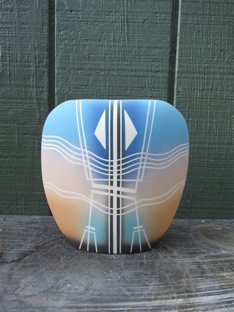 A boldly textured ceramic pot brightly painted in an intricate geometric pattern with leather and feather accents. Vintage Southwestern Vase Vintage Ceramic Southwestern ...