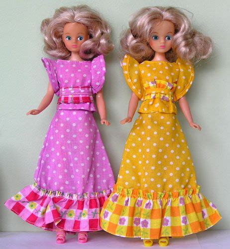 Two Dolls Are Standing Next To Each Other On A Table With One Doll