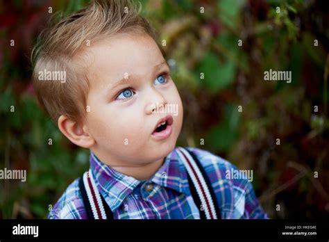 Portrait Of Cute Little Boy With Big Blue Eyes And A Stylish Hairstyle