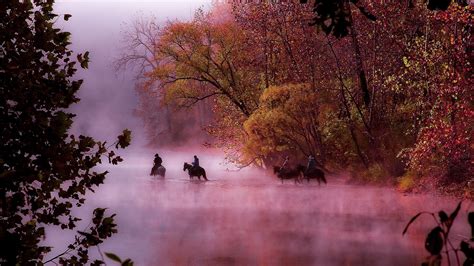 Horses And Riders Crossing The River On A Foggy Morning In The Ozarks