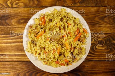Pilaf With Meat Rice Carrot And Onion In A Plate On Wooden Table Top