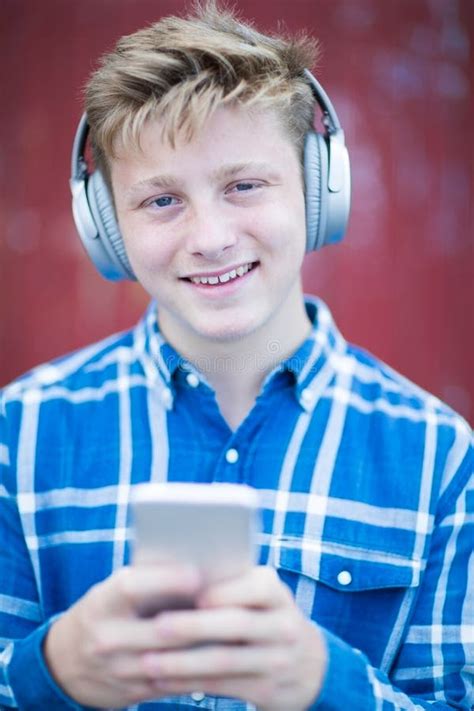 Portrait Of Teenage Boy Wearing Wireless Headphones And Listening To